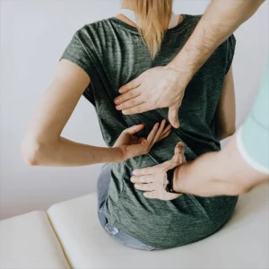 chiropractor adjusting woman's spine- sciatica pain