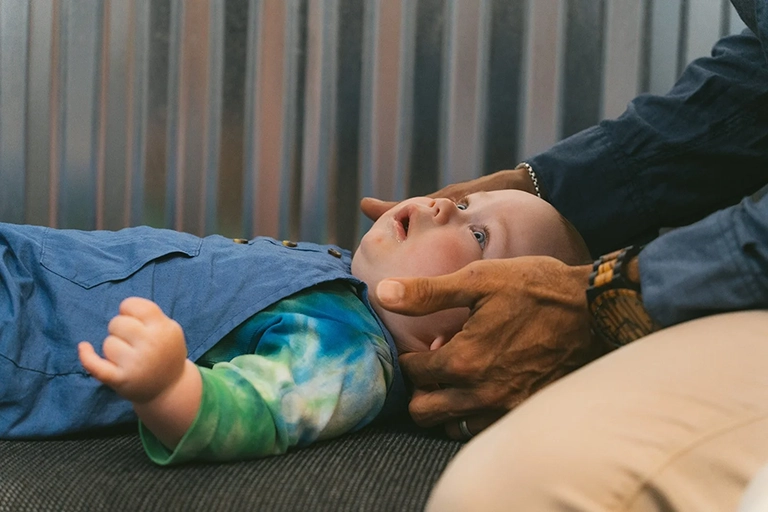 baby getting neck and spinal adjustment - pediatric chiropractic