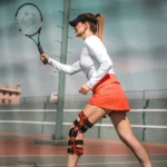 woman playing tennis with sports injury - chiropractic care for sports injury