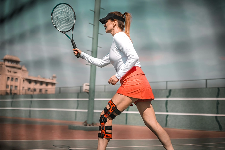 woman playing tennis with sports injury - chiropractic care for sports injury